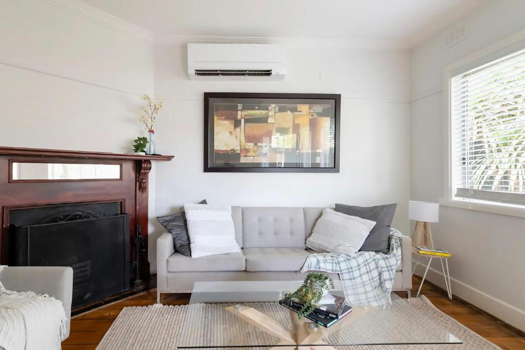 ein Wohnzimmer mit einem Sofa und einem Kamin in der Unterkunft Inner city home West Footscray close to everything in Seddon