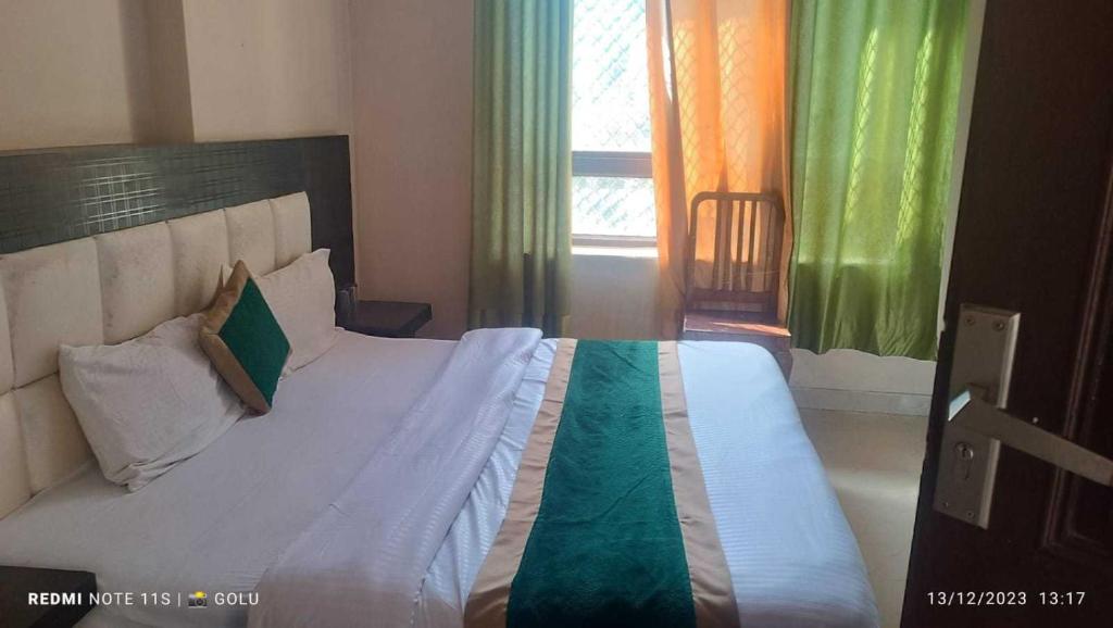 a bedroom with a large bed with green and orange curtains at Kavi Home Stay in Mussoorie