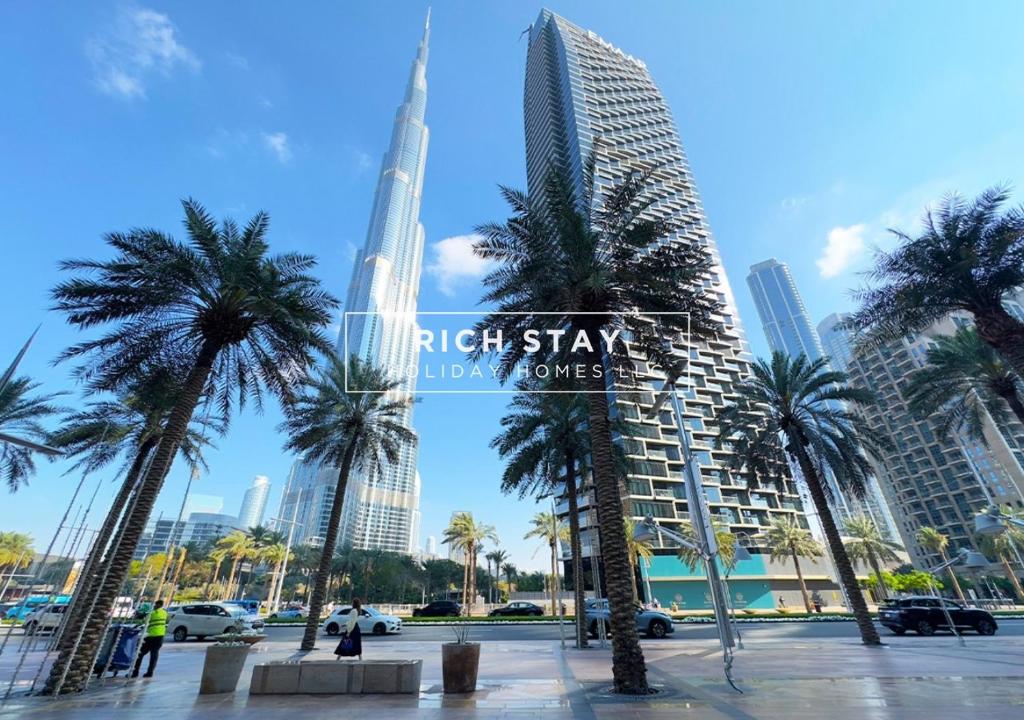 a city with palm trees and a sign that reads night stay new towers at Superb 1BR at Burj Vista In Downtown Dubai in Dubai