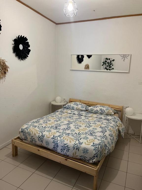 um quarto com uma cama com um edredão azul e branco em Bel appartement proche du centre ville em Montpellier