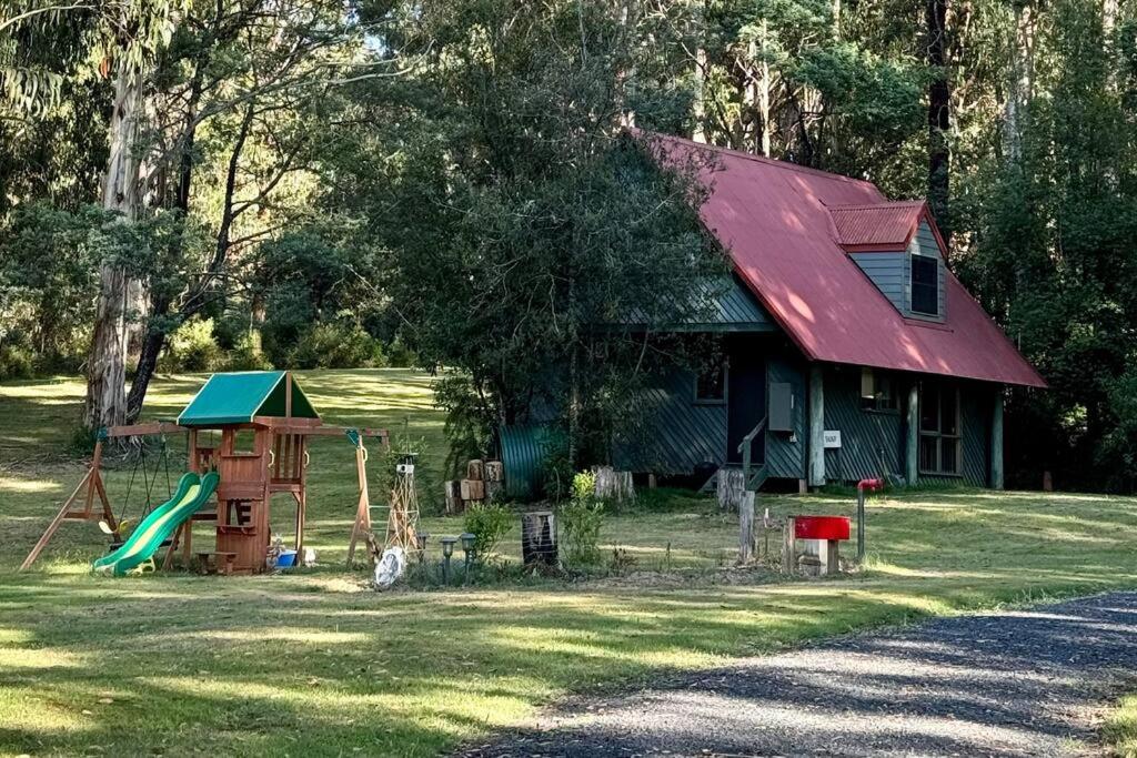 uma casa com um parque infantil no quintal em Tranquil getaway amidst nature in Icy Creek em Fumina