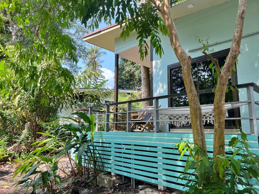象島的住宿－Sleep Inn - Lonely Beach，花园内带蓝色长椅的房子