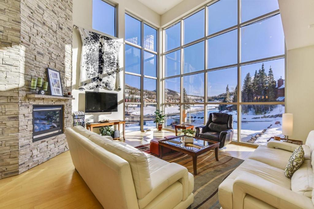 a living room with a fireplace and a large window at Slopes_loft in Brian Head