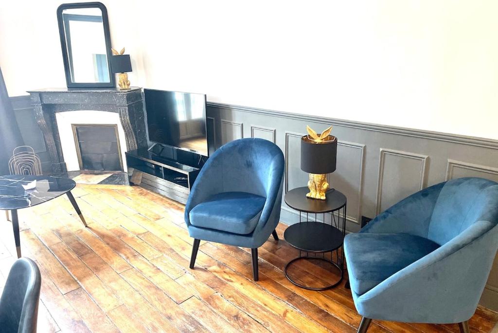 un salon avec deux chaises bleues et une table dans l'établissement Bon'Appart centre-ville charme, à Fontainebleau