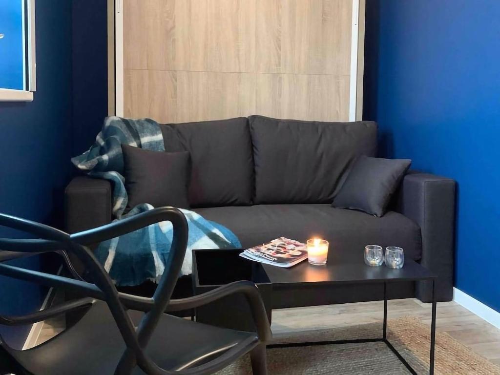 - un salon avec un canapé et une table avec une bougie dans l'établissement Le Tribunal - Studio près de l’avenue des Vosges, à Strasbourg
