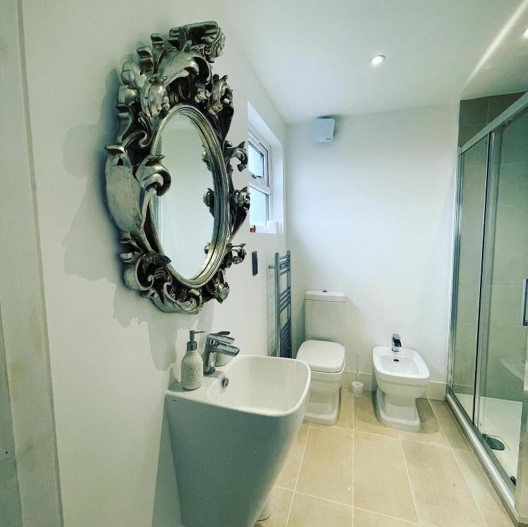 a bathroom with a sink and a mirror on the wall at Private Bright Bedroom with Ensuite River View in Kent