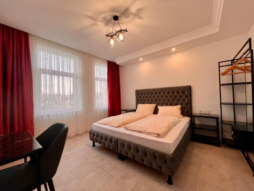 una camera da letto con un grande letto con tende rosse di Durmaz Hotel ad Hannover