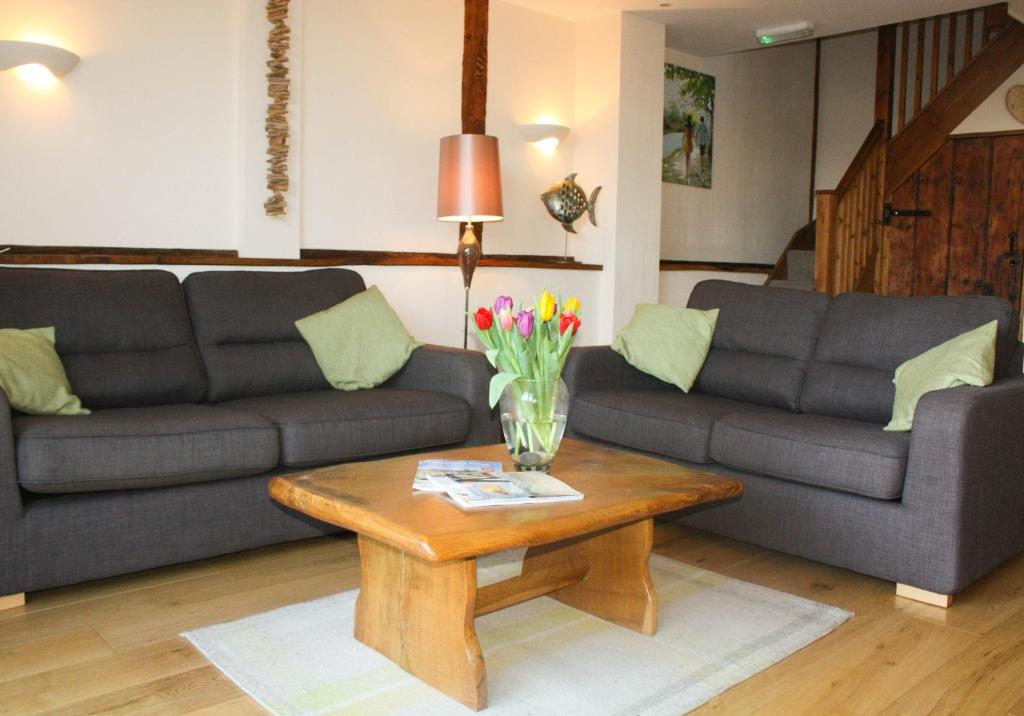 a living room with two couches and a coffee table at The Hayloft at Carpenters Farm in Colchester