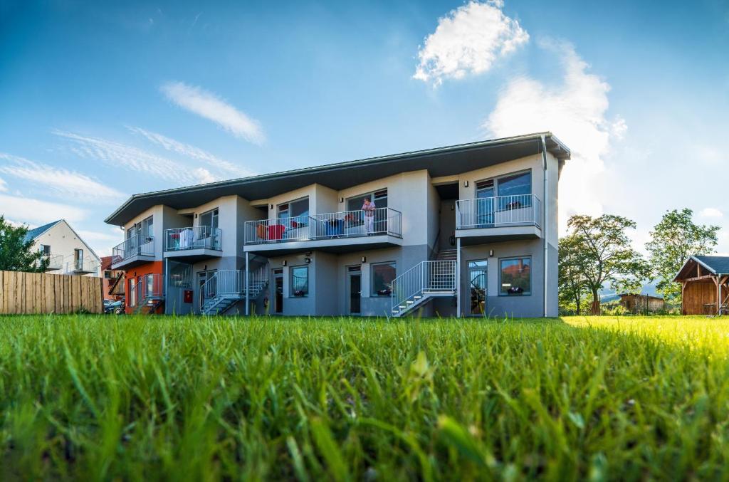 ein großes Apartmenthaus mit einem grünen Feld davor in der Unterkunft Apartmány Vera in Bešeňová