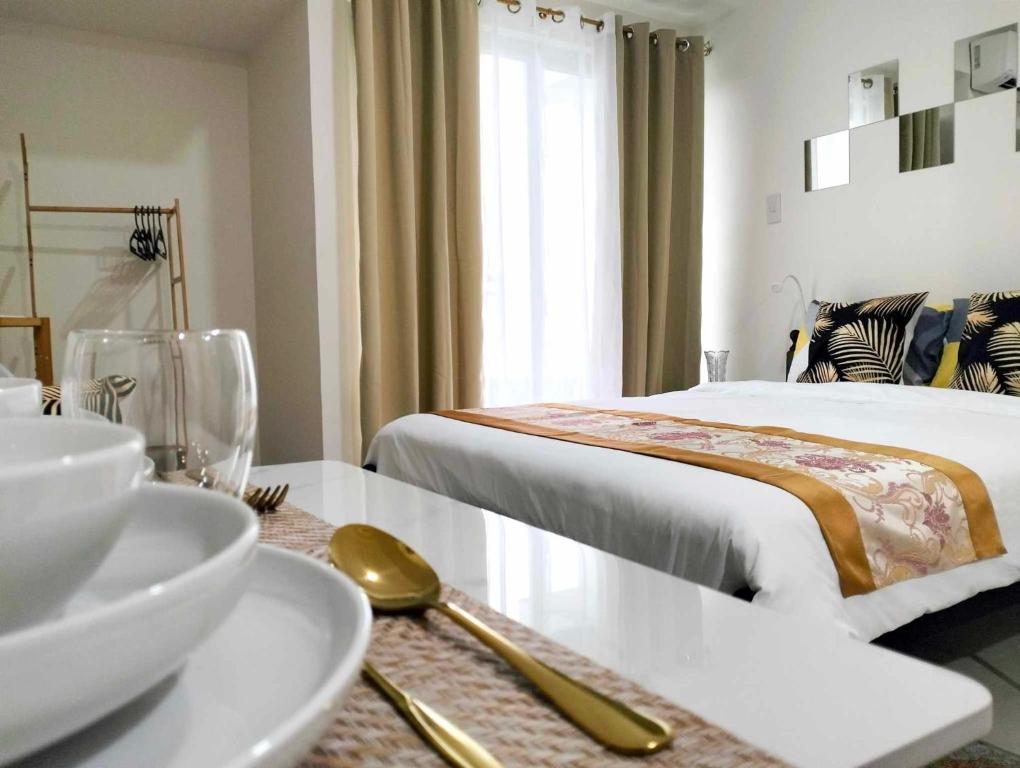 a hotel room with a bed and a table with a bowl at Goldentel at Inspiria Condo Davao City in Davao City