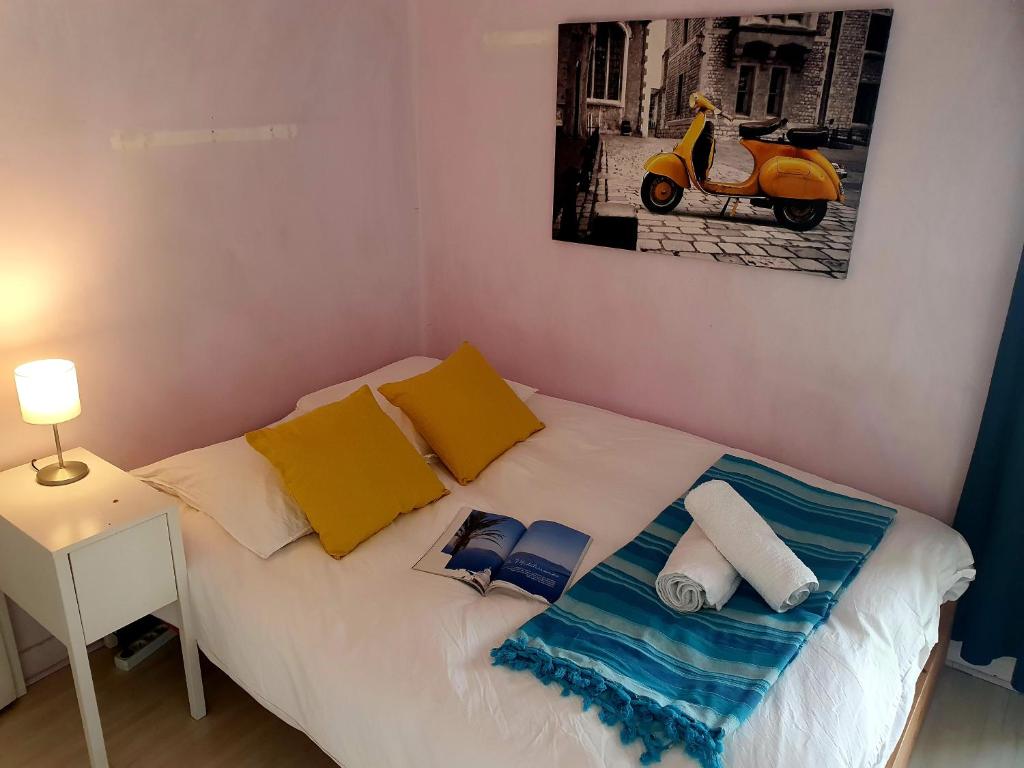 a small bedroom with a bed with a scooter on it at Vue sur Paris in Ivry-sur-Seine