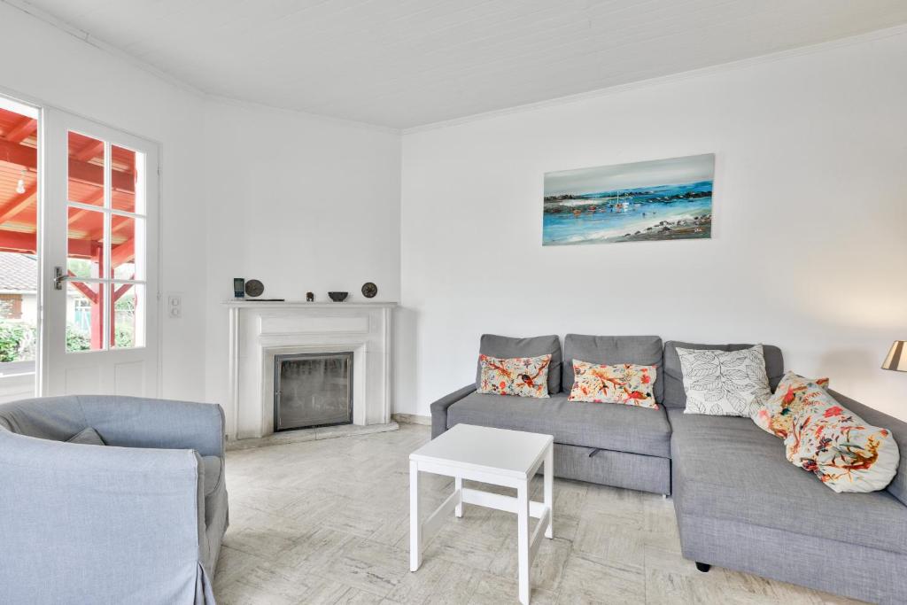 un salon avec un canapé et une table dans l'établissement Maison pour 10 - jardin - 600 m de la plage, à Andernos-les-Bains