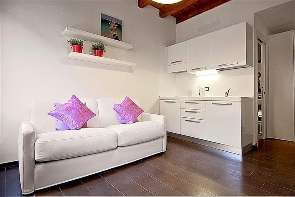 Il comprend un salon avec un canapé blanc et une cuisine. dans l'établissement Apartments Florence - San Gallo 3, à Florence