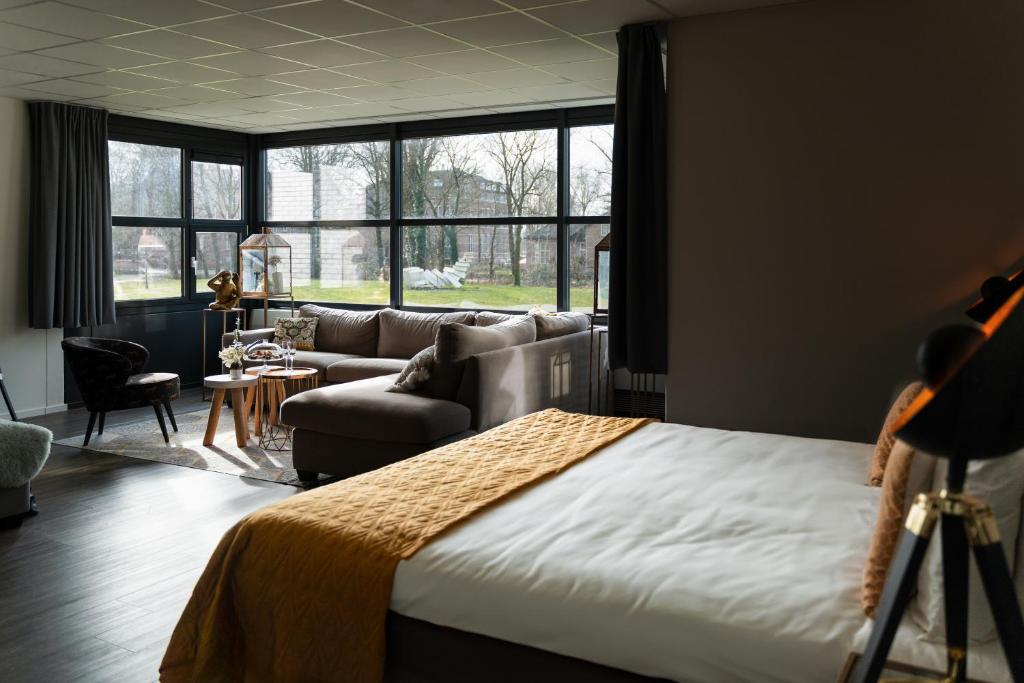 um quarto com uma cama, um sofá e uma mesa em Hotel WICC em Wageningen