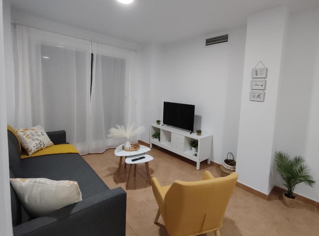 sala de estar con sofá y TV en Apartamento en Sevilla con piscina y parking, en La Algaba