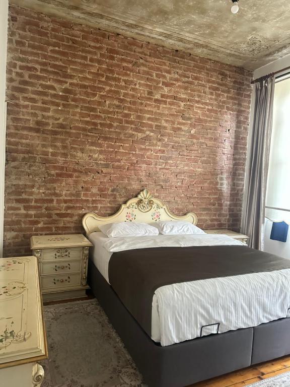 a bedroom with a brick wall and a bed at Youkali hause in Istanbul