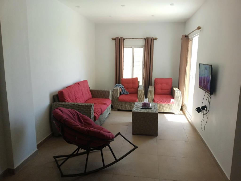 Riḩāb的住宿－شاليه الضياء，客厅配有两把椅子和一张沙发