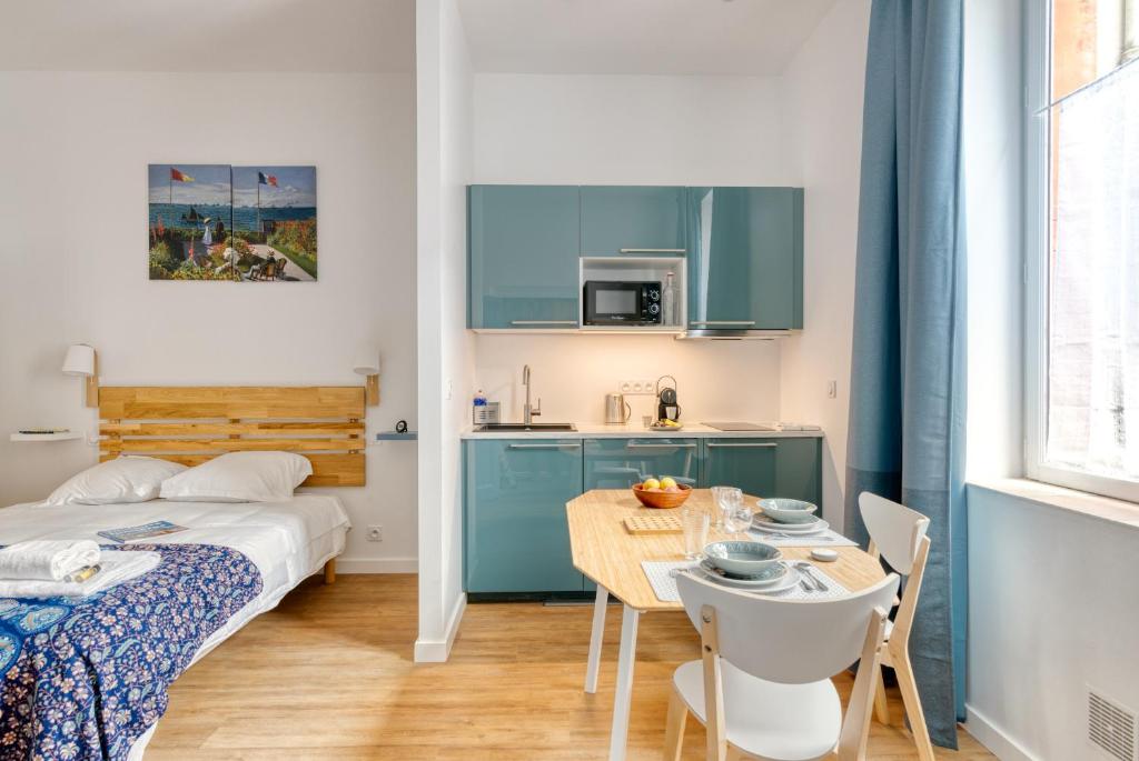 Cette chambre comprend un lit, une table et une cuisine. dans l'établissement Sainte-Catherine by Yumē, à Toulouse