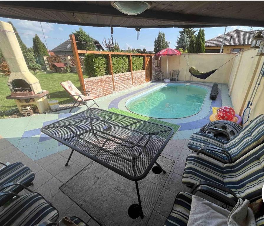 Un patio con mesa y sillas junto a una piscina. en dom pri X Bionic Sphere s bazenom a zahradou, en Kalinkovo