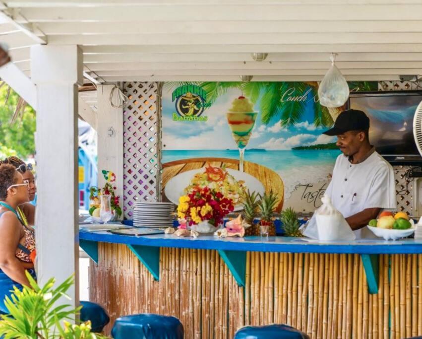 um homem parado em frente a uma banca de comida em Paradise Villa em Nassau