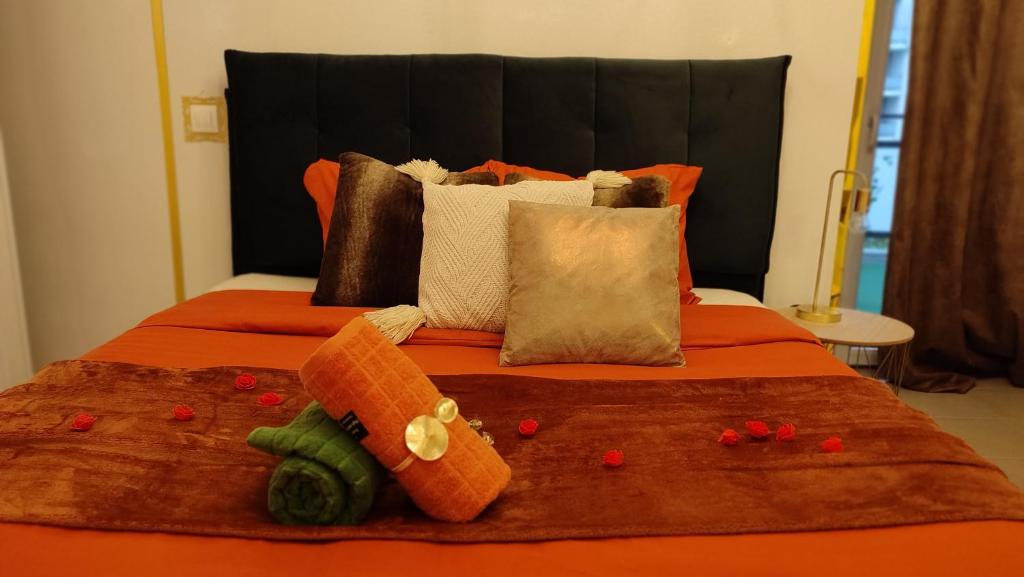 uma cama com um edredão de laranja com vegetais em ESCAL'HOME appart design au pied de l'aéroport, parkings em Blagnac