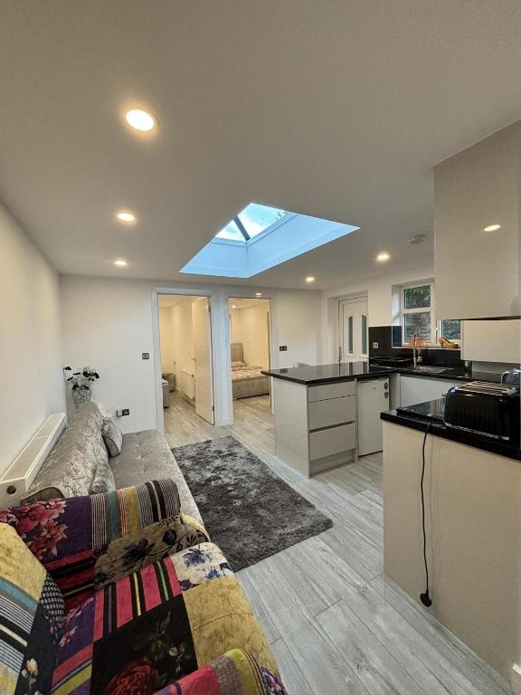 ein Wohnzimmer mit einem Sofa und eine Küche mit einem Fenster in der Unterkunft Cozy 2 Bed Property in High Wycombe Tn in High Wycombe