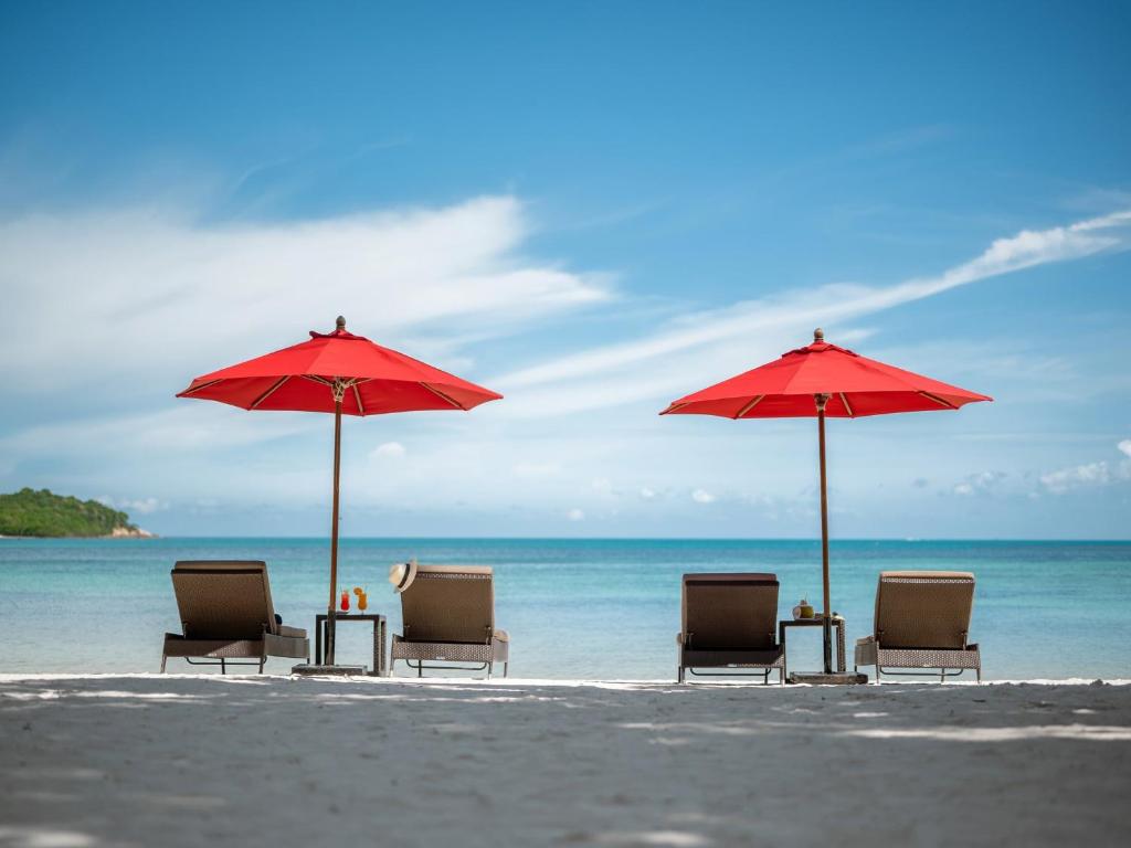a group of chairs and umbrellas on a beach at Amari Koh Samui in Chaweng