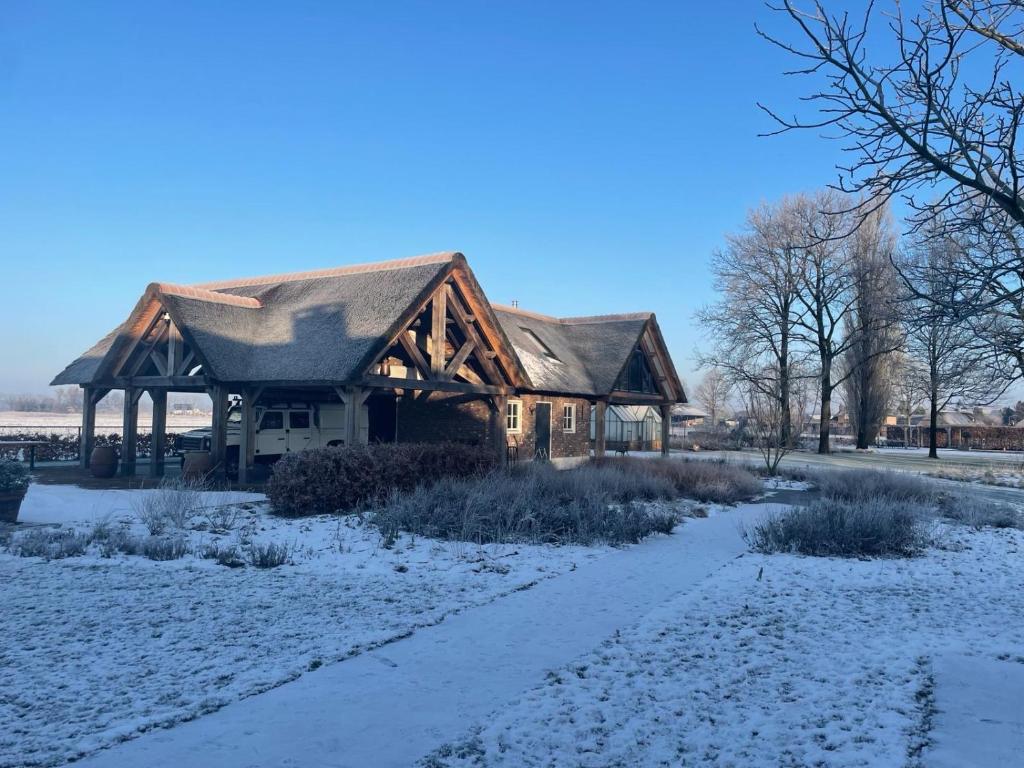 una cabaña de madera en la nieve con un camino en B&B Il Settimo Cielo, en Someren