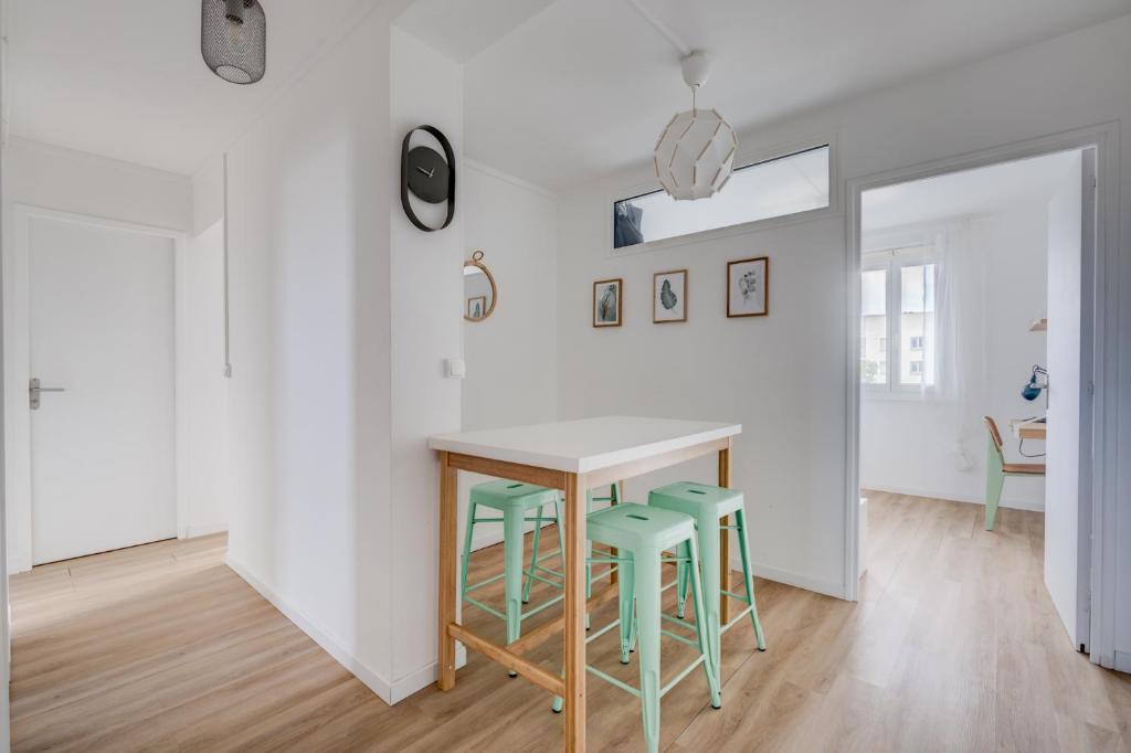 une cuisine avec une table et quatre tabourets verts dans l'établissement Mermoz by Yumē, à Toulouse