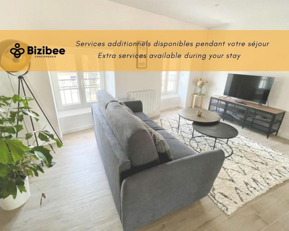 un salon avec un canapé et une table dans l'établissement Le jardin des Hautes Presles Le Fer à cheval, à Fontainebleau