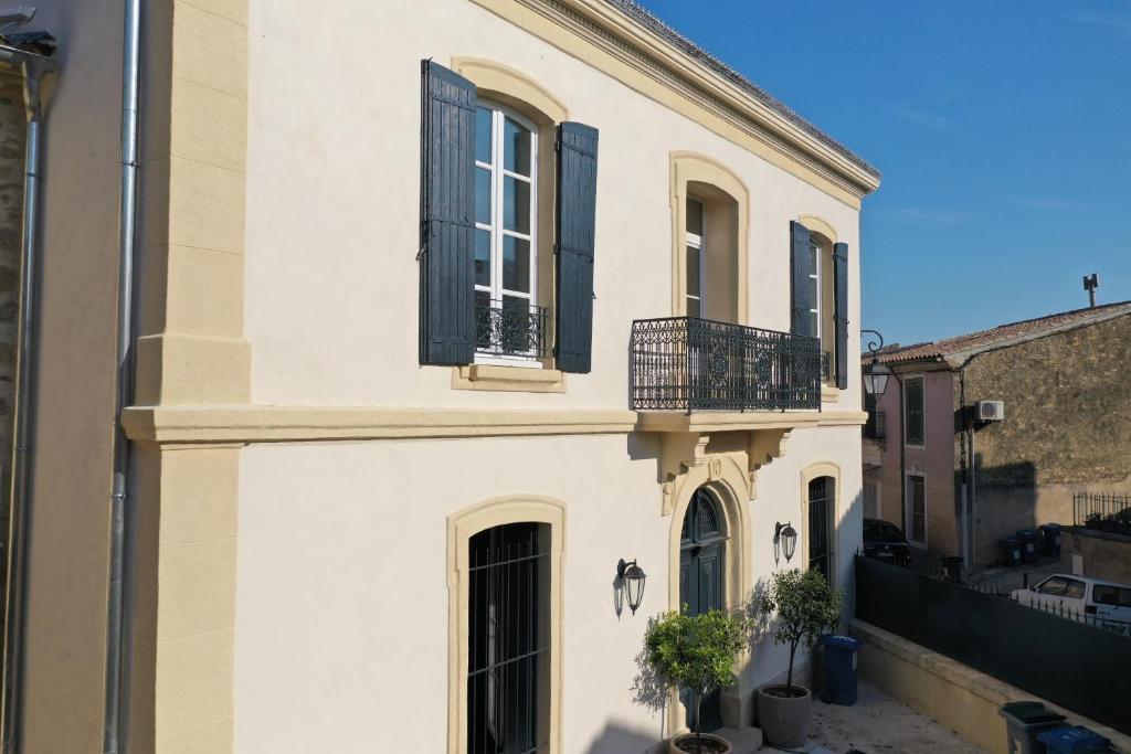 Cette maison blanche dispose de fenêtres noires et d'un balcon. dans l'établissement camarina-lodging, à Beauvoisin