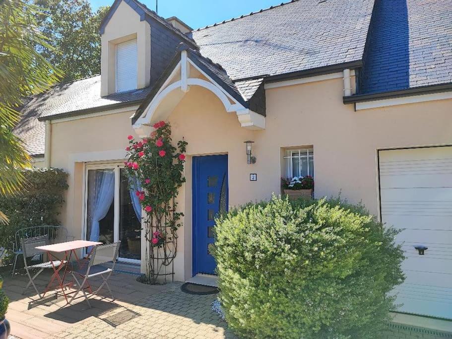 een wit huis met een blauwe deur en een tafel bij Maison Pornichètine classée 3 étoiles à 700m plage a pieds in Pornichet