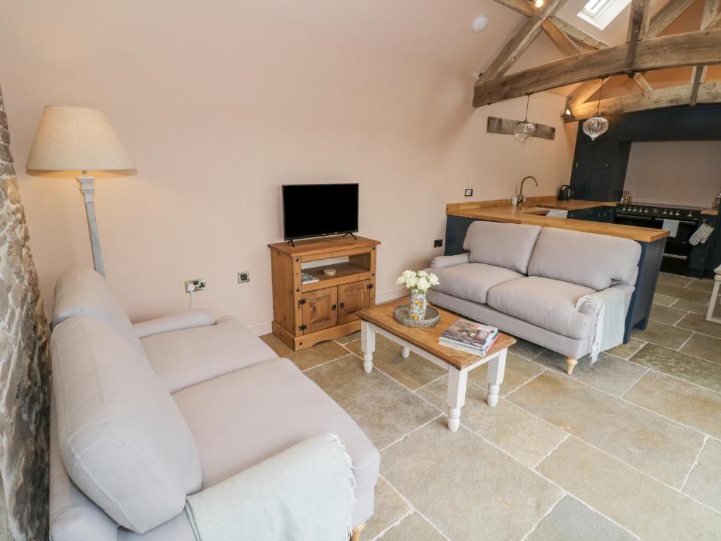 Una sala de estar con dos sofás y un televisor. en Meadow Barn, en Leominster