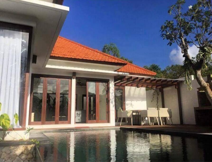 a house with a swimming pool in front of it at Villa Waimea in Uluwatu
