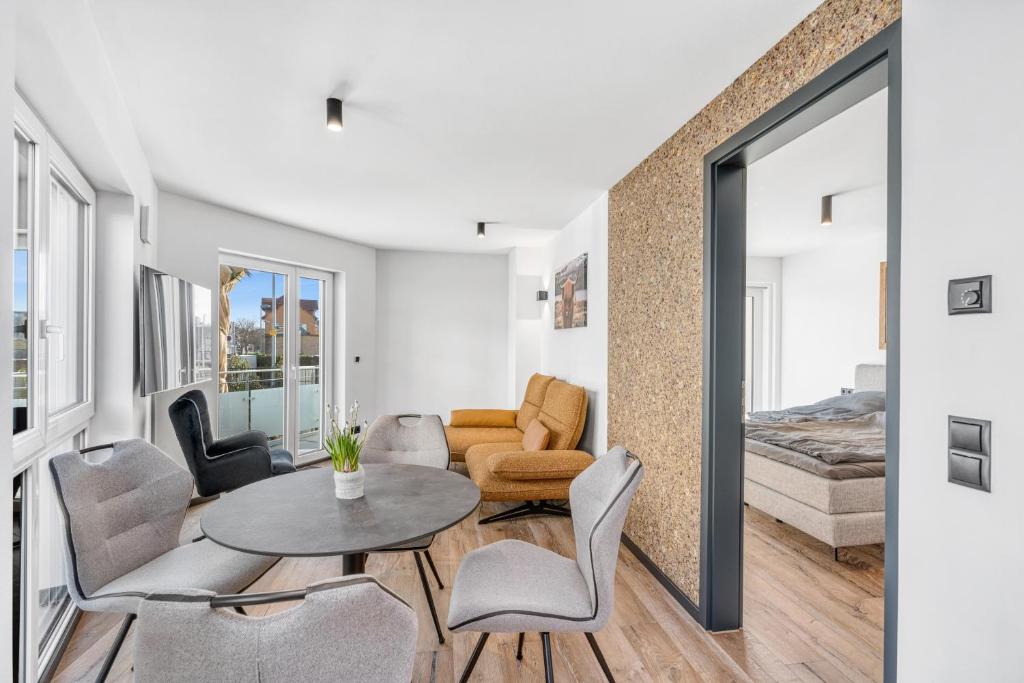 ein Wohnzimmer mit einem Tisch, Stühlen und einem Sofa in der Unterkunft Seequartier 1 - neu & hochwertig in Friedrichshafen