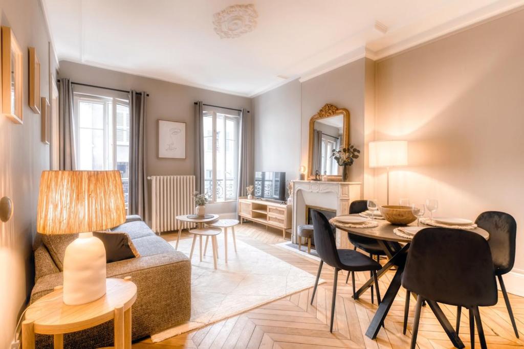 un salon avec un canapé et une table dans l'établissement Le France - Les Jardins du Roi, à Fontainebleau