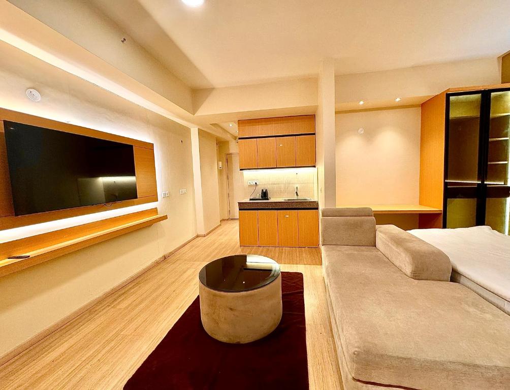 a living room with a couch and a large flat screen tv at ARMERIA STAY DLF MY PAD in Lucknow