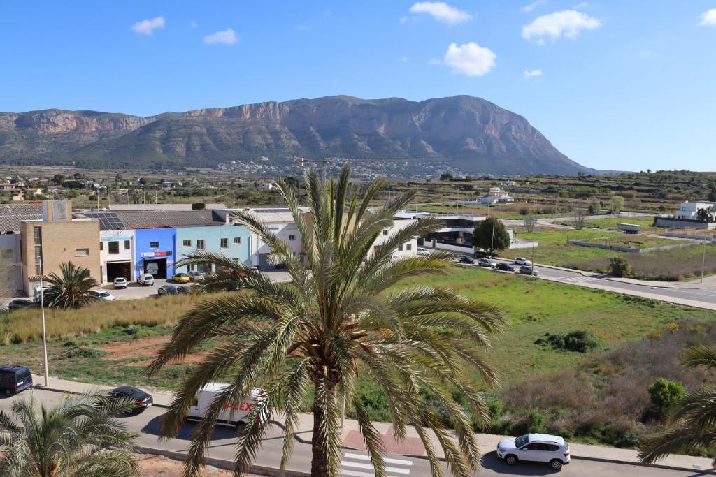 a town with palm trees and a mountain in the background at Gata de Gorgos in Gata de Gorgos