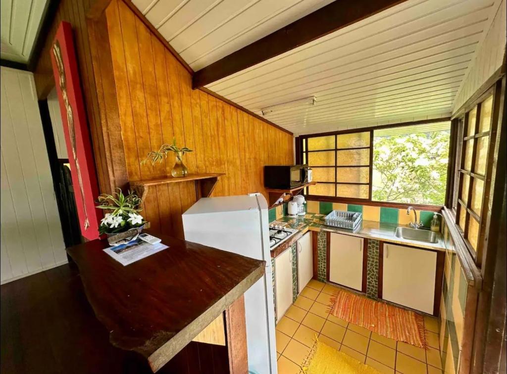 a kitchen with a white refrigerator in a room at Fare miti access private white sand beach in Moorea
