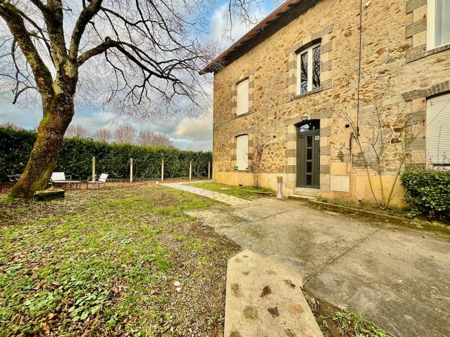 un bâtiment en briques avec un arbre devant lui dans l'établissement LesCinqSuites/12 couchages-DABNB, à Limoges