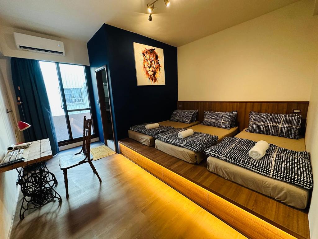 una camera da letto con due letti e una scrivania di Liu Xu Homestay ll a Tainan