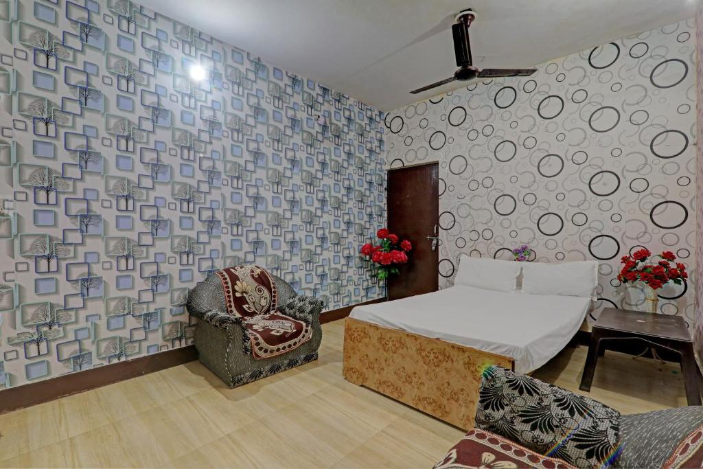 um quarto com uma cama, uma cadeira e uma mesa em OYO The Home em Lucknow