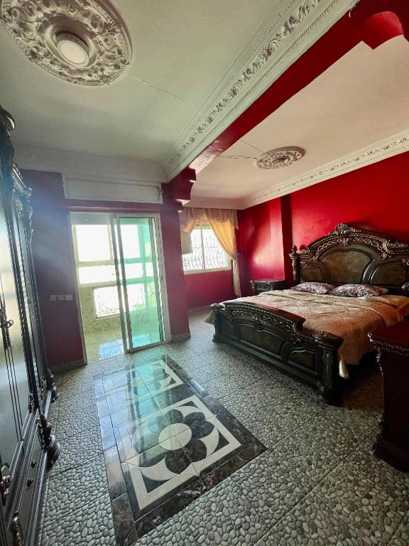a bedroom with a bed and a red wall at Refined Me Apartment Bb in Casablanca