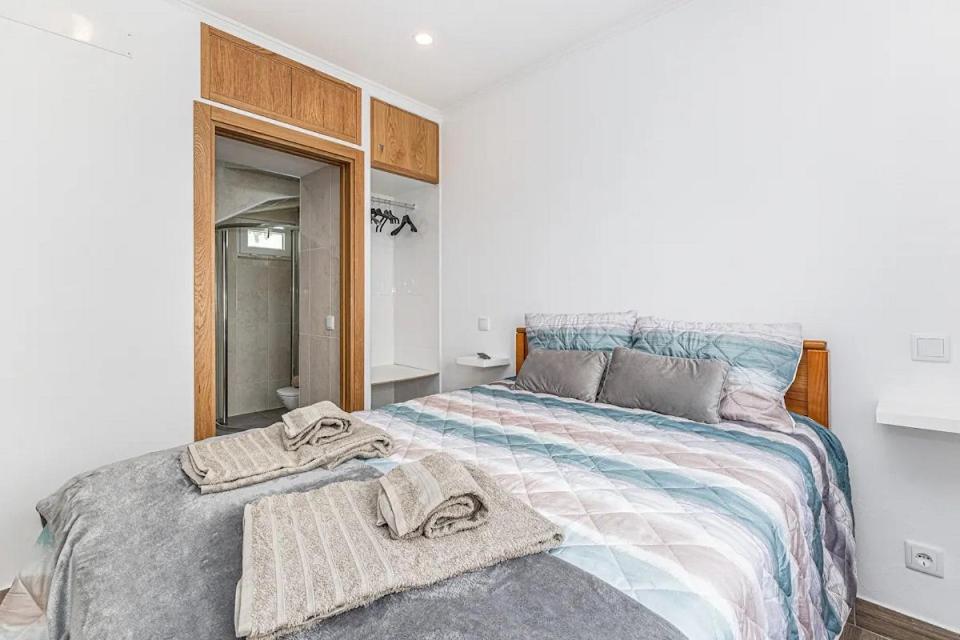 a bedroom with a large bed with towels on it at Casa da Avó - City Center - Private Bedrooms in Lagos