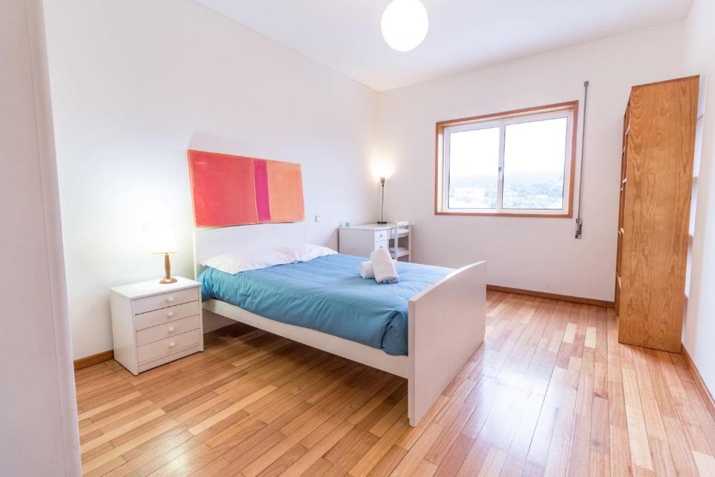 a white bedroom with a bed and a window at Quinta da Armada, Apartamento em Braga by House and People in Braga