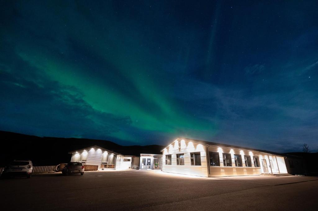 un bâtiment avec l'aurore dans le ciel la nuit dans l'établissement Hótel Skógafoss by EJ Hotels, à Skogar