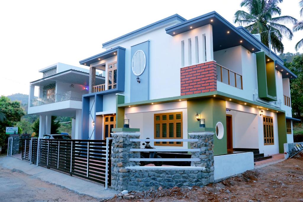 una casa con una fachada azul y blanca en Oxygen Home Stay, en Agali
