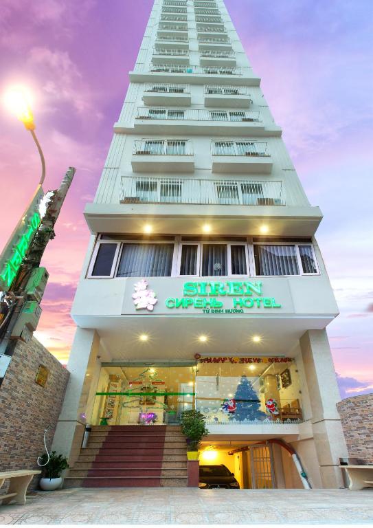 a tall white building with a store front at Siren Flower Hotel in Nha Trang