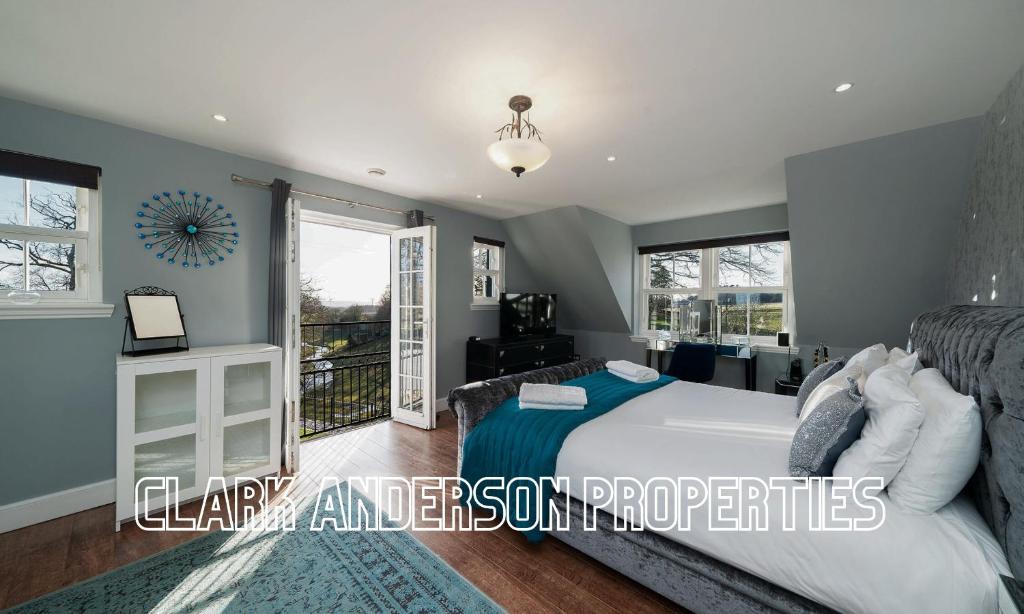 a bedroom with a bed and a large window at Thatched Cottage in Broughty Ferry