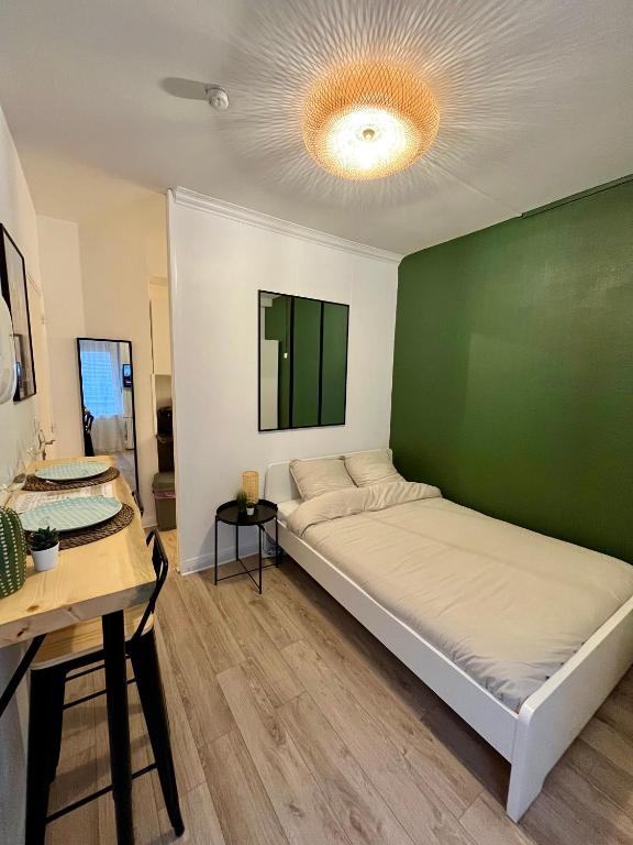 Bett in einem Zimmer mit grüner Wand in der Unterkunft Au ColbVert in Lille